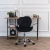 A black office chair is placed in front of a wooden desk with shelves, in a room with white paneled walls and wooden flooring. Produktbild-Vorschau