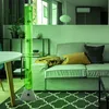 A living room with a sofa, table, and a tall bubble lamp with fish. Produktbild-Vorschau