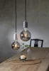 Two decorative LED light bulbs hanging over a wooden table with a candle and a vase. Podgląd zdjęcia produktu