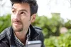 A man is looking away from the camera while holding a phone. Podgląd zdjęcia produktu