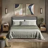 A bedroom scene with a bed, nightstands, and artwork. Voir les images du produit
