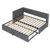 A dark gray upholstered bed frame with a pull-out trundle bed is shown from a slightly elevated, diagonal angle against a white background. The bed frame has a channel-tufted headboard that wraps around two sides. The wooden slats of the main mattress base Produktbild-Vorschau