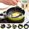 A hand is shown cracking an egg into a heart-shaped egg ring in a frying pan, with a series of numbered images below showing the process of making an omelet or fried egg. Produktbild-Vorschau