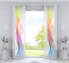 Two panel curtains with a rainbow wave pattern are displayed in front of a window with a view of trees and sky.