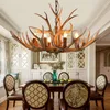 A dining room with a chandelier and dining table set for a meal. Podgląd zdjęcia produktu