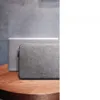 A laptop and its sleeve are placed on a wooden table. Produktbild-Vorschau
