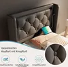 A close-up view of a bed's upholstered headboard with a tablet charging via a USB port. Produktbild-Vorschau