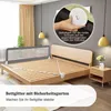 A bed with a safety rail installed, showing how to secure it with straps. Voir les images du produit