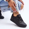 A person is wearing black sneakers and blue ripped jeans. Produktbild-Vorschau