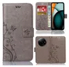 A collage of images showing a gray flip phone case with a floral pattern, a phone inside the case, and a close-up of the phone's camera. Produktbild-Vorschau