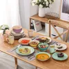 A table set with a 20-piece porcelain dinnerware set for four people, including plates, bowls, and mugs, arranged for a meal. Náhled obrázku produktu