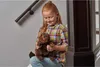 A young girl is sitting on stairs holding a stuffed beaver. Náhled obrázku produktu