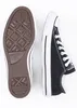 A top-down view of a pair of black Converse All Star sneakers, showing the sole of one shoe and the side of the other. Voir les images du produit