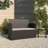 A poly rattan garden bench with cushions is placed on a gravel patio next to a building. Anteprima dell’immagine prodotto