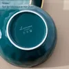 The bottom of a teal ceramic bowl with a white rim, showing the brand logo and care symbols. Náhled obrázku produktu