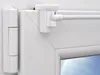 Close-up of a white window hinge and a window security hook. Voir les images du produit
