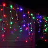 Colorful LED icicle lights hanging on a wooden wall at night. Produktbild-Vorschau
