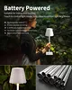 A woman holding a portable lamp in an outdoor setting, with close-ups of the lamp and metal tubes. Produktbild-Vorschau