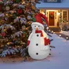 A festive outdoor scene with a decorated Christmas tree and a lit snowman decoration in front of a house. Voir les images du produit