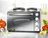 A countertop oven with two burners on top, placed on a counter with vegetables around it. Produktbild-Vorschau