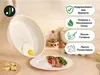 A frying pan with a fried egg in it, along with a plate of food and some cheese, set against a light wooden background. Informational icons and text are displayed on the right side. Náhľad obrázku produktu