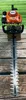 A Stihl hedge trimmer is shown from the front, resting on a wooden surface with a grassy background. Produktbild-Vorschau