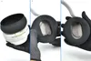 A close-up view of black headphone ear pads being handled by gloved hands, showing a disassembly or replacement process. Náhľad obrázku produktu