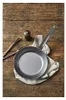 A frying pan, tongs, and a pepper grinder are arranged on a wooden surface. Náhľad obrázku produktu