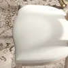 A close-up view of a cream-colored chair seat on a patterned rug. Náhled obrázku produktu