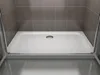 A close-up view of a modern shower tray with a drain in the center, set against tiled walls and a wooden floor. Produktbild-Vorschau