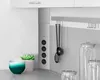 A kitchen counter with a power strip, utensils, and storage jars. Produktbild-Vorschau