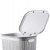 A close-up view of the top part of a grey plastic laundry basket with its lid open. Produktbild-Vorschau
