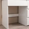 A close-up view of the side and bottom of a white dresser or vanity. Podgląd zdjęcia produktu