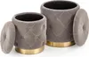Two upholstered ottomans with lids, one slightly larger than the other, are shown against a white background. Both have a tufted design and a gold-colored base. The lids are slightly ajar. Produktbild-Vorschau