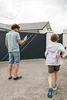 A man and a child are walking towards a gate in front of a house. Anteprima dell’immagine prodotto