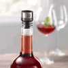 A close-up of a wine bottle with a vacuum stopper, with a blurred wine glass in the background. Produktbild-Vorschau