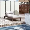 A poolside lounge area with a chaise lounge, privacy screens, and a small fountain. Produktbild-Vorschau