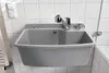 A gray sink with a chrome faucet and a pull-out hose is mounted on a tiled wall. Anteprima dell’immagine prodotto