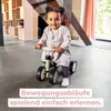 A young child is riding a Puky PUKYLINO balance bike indoors. Voir les images du produit