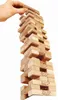 A hand is shown pulling a wooden block from a Jenga tower. Produktbild-Vorschau