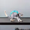 A toy figurine of a creature with blue crystalline spikes on its back is displayed on a dark shelf against a light gray background. Voir les images du produit