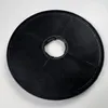 A round, black carbon filter with a central hole, lying on a light-colored surface. Anteprima dell’immagine prodotto