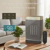 A ceramic heater is shown in a living room setting, placed on a coffee table next to a plant and an open book. The heater has a digital display and a remote control is visible. Produktbild-Vorschau