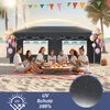 A group of people enjoying a picnic on the beach under a canopy. Voir les images du produit