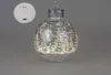 A decorative Christmas ornament with LED lights and a winter forest scene. Produktbild-Vorschau