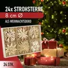 A box of straw stars is placed in front of a decorated Christmas tree with gifts underneath. Produktbild-Vorschau