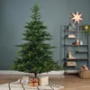A decorated Christmas tree in a room with shelves and gifts. Voir les images du produit