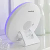 The back of a white digital alarm clock with a purple light strip is shown, resting on a white surface. Produktbild-Vorschau