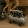 A person is using an air compressor to inflate a car tire. Produktbild-Vorschau
