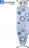 A light blue ironing board cover with a floral pattern, standing upright against a white background. The top of the ironing board is visible, with a silver metal holder attached. Produktbild-Vorschau